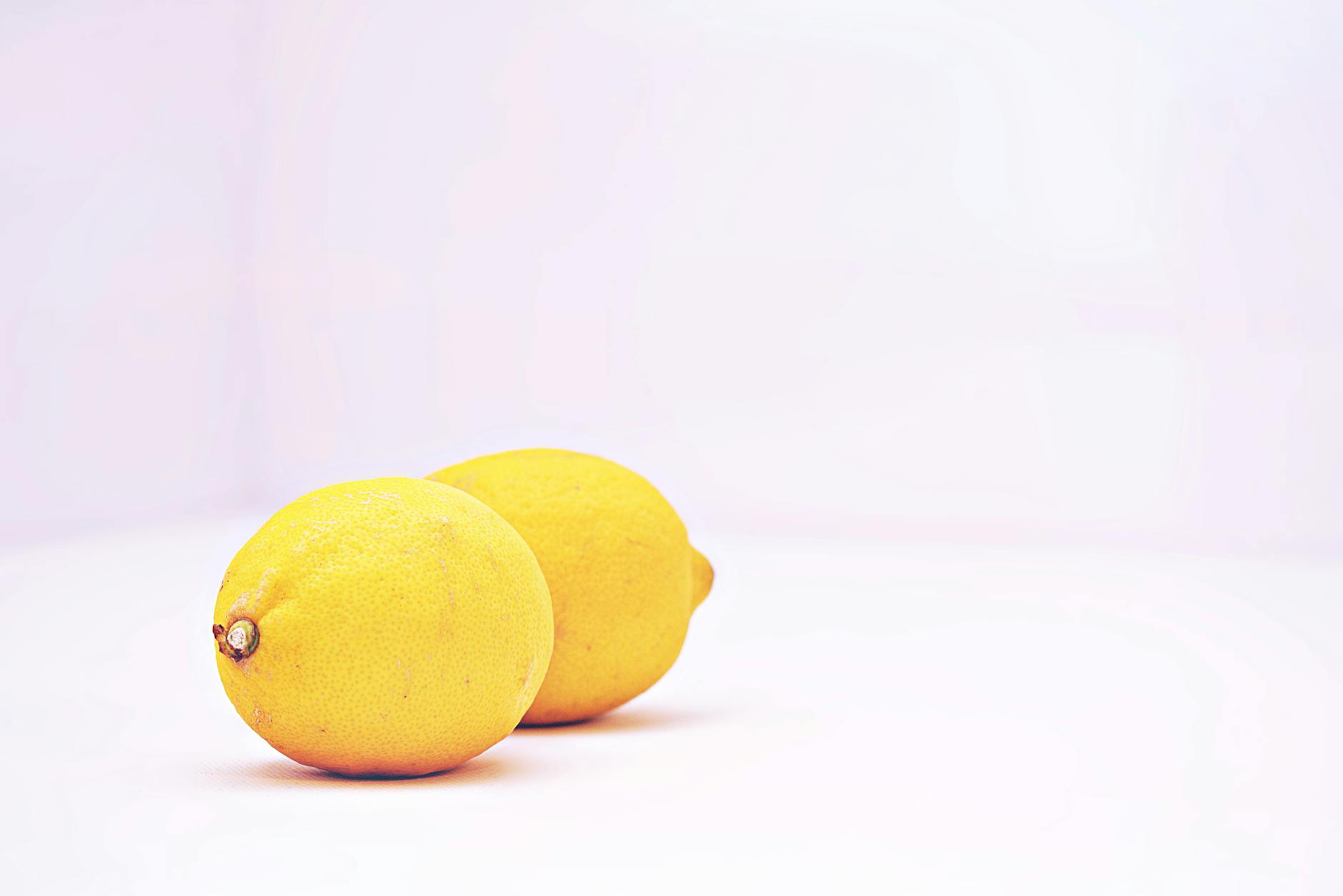 Close-up of hands holding a lemon vibrator against a soft knitted sweater