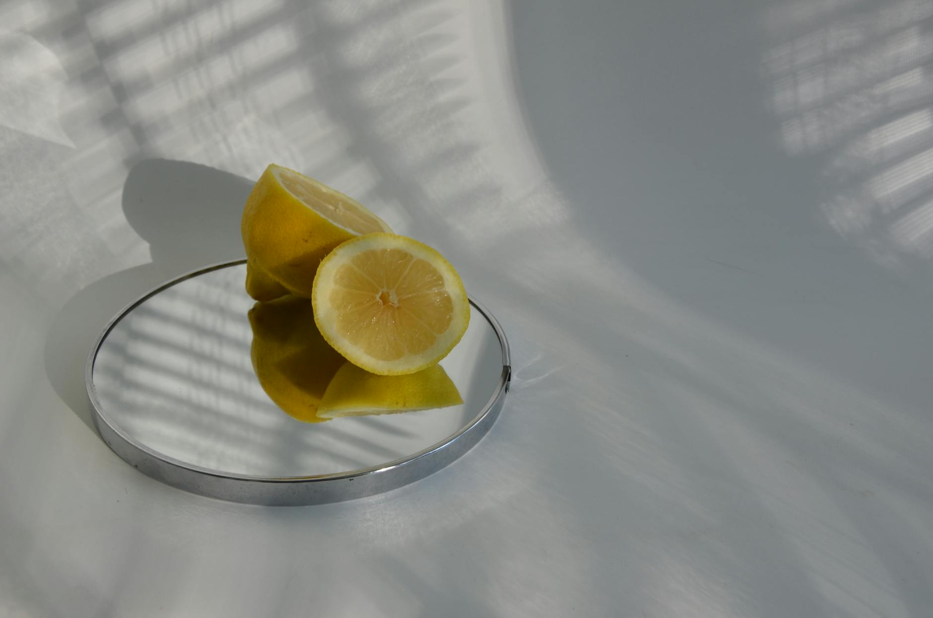 Citrons tranchés créant des ombres nettes sur une surface brillante, symbolisant la clarté et la fraîcheur du plaisir sans tabou