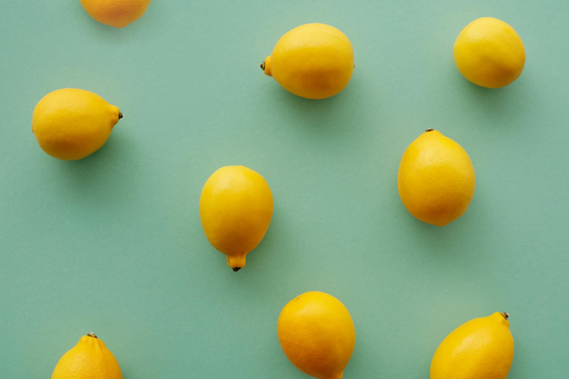 Bright yellow lemons arranged on a pastel green background, representing fresh starts and new experiences