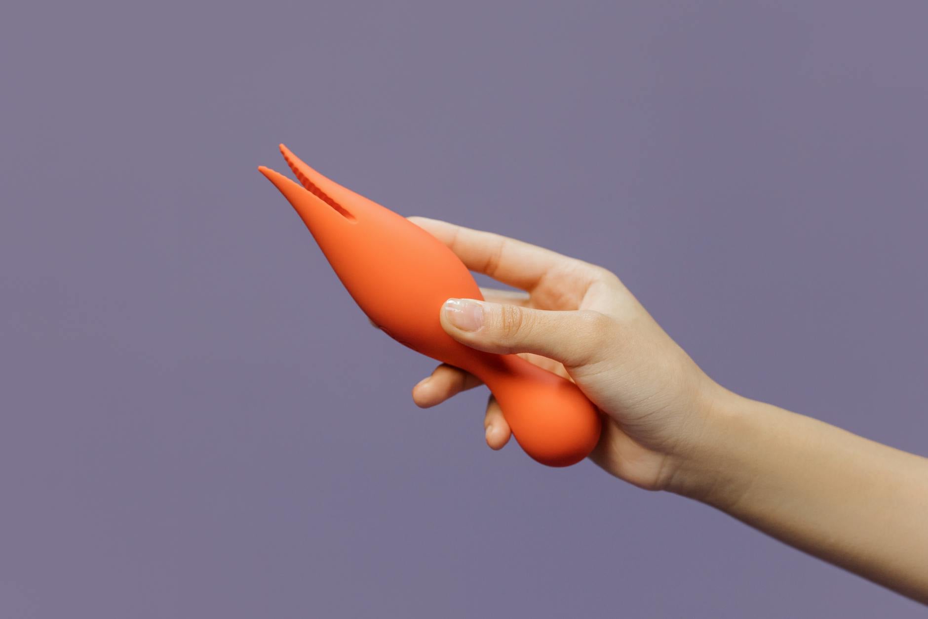 Close-up of a hand holding a lemon vibrator against a minimalistic backdrop, symbolizing modern sensuality and reconnection.