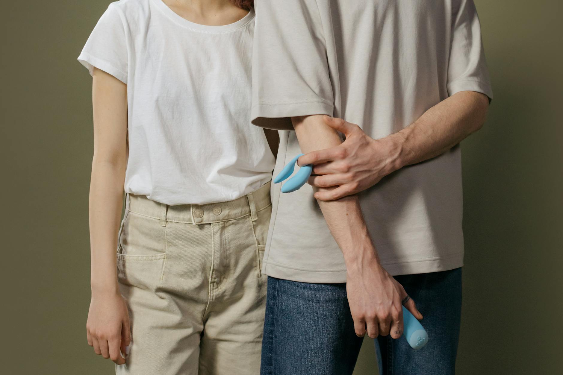 Une main tenant un vibromasseur orange vif sur un fond minimaliste et violet, symbolisant la sensualité moderne et le plaisir personnel